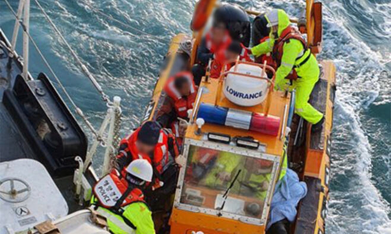 지난 1월 29일 침몰한 제주선적 3600t급 화물선 삼성 1호에서 구조된 선원들을 인계하고 있다. [사진=완도해경]