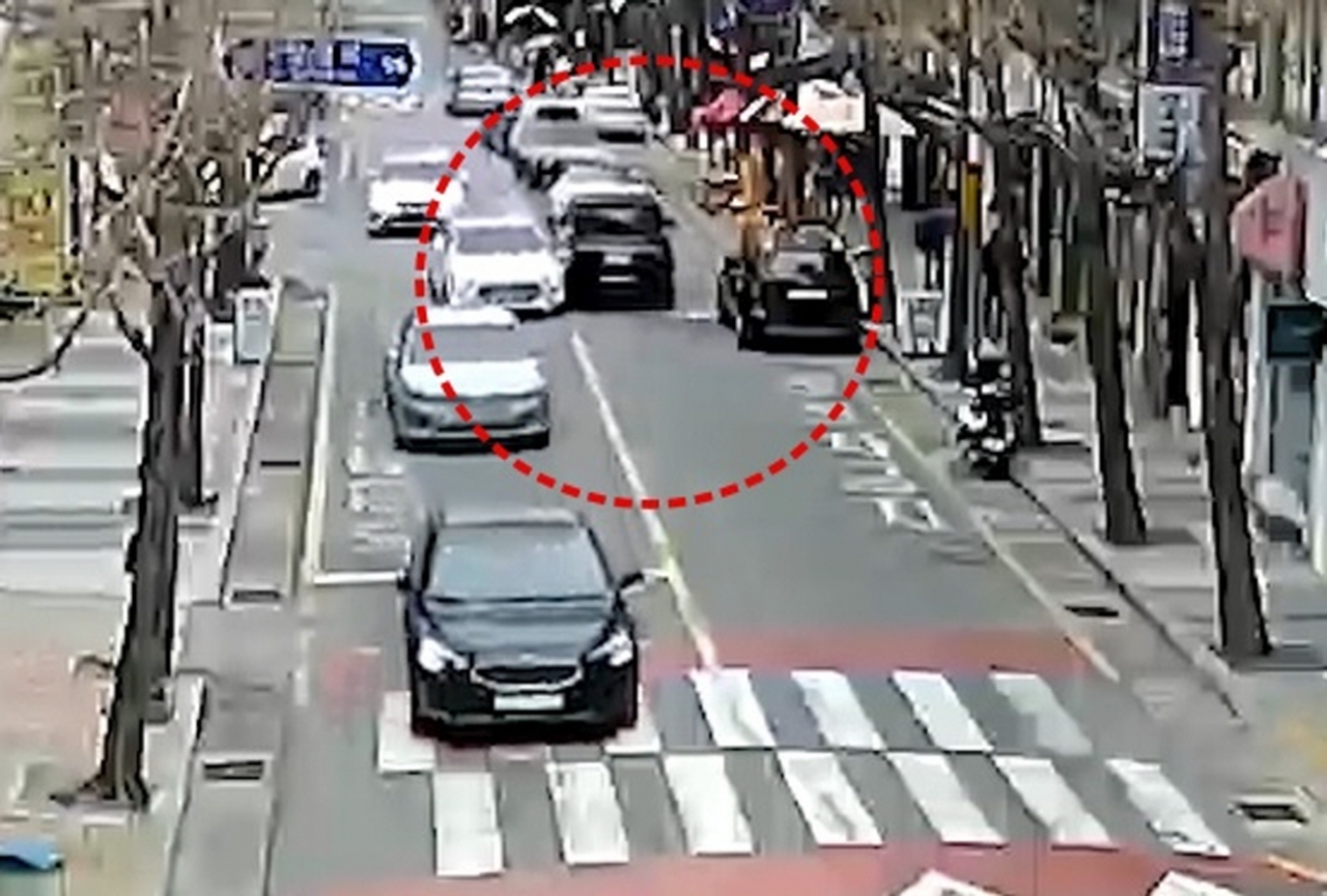 범행 일당의 차량(원안 왼쪽 흰색)이 정차된 차량을 피해 중앙선을 침범해 달리던 차량(원안 가운데)을 상대로 고의 첩촉사고를 일으키고 있다. [사진=경남경찰청]